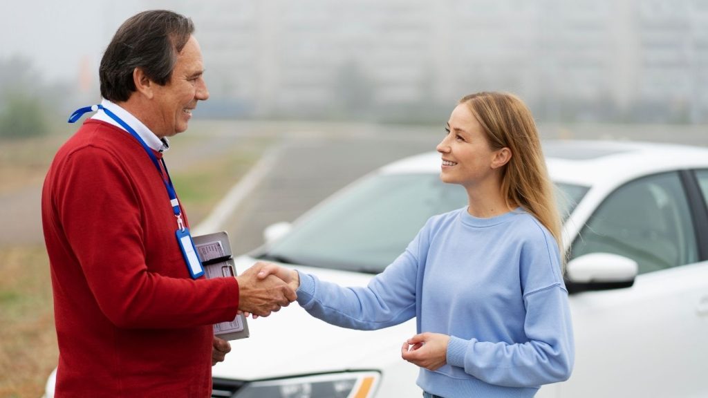 Affordable Auto Insurance Pearland TX | Trusted Coverage 25 Happy customer shaking hands with insurance agent after Auto Insurance Pearland TX approval beside a white car.