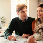 A couple with their pet dog meeting with a McKinney home insurance agent to discuss coverage options.